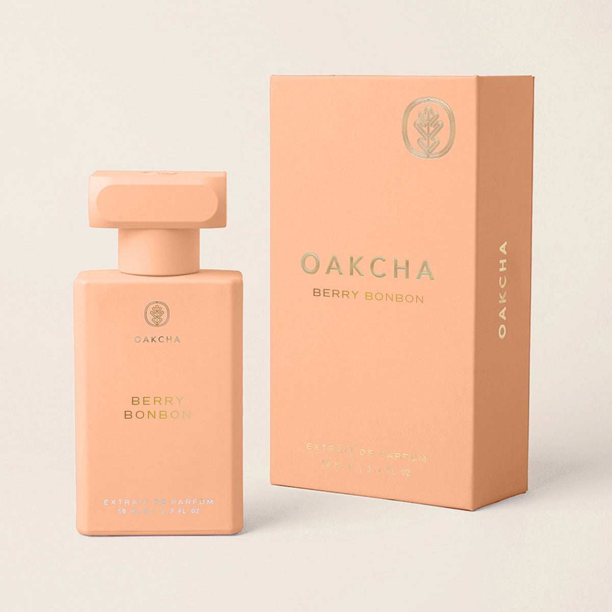 Front view of Berry Bonbon perfume bottle and box showcasing peach pink packaging with gold accents