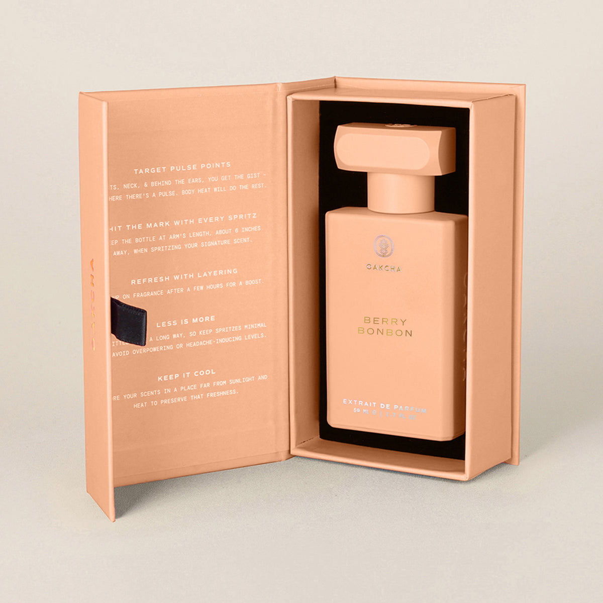 Front view of Berry Bonbon perfume in an open peach pink box, showcasing its rectangular bottle and matching cap