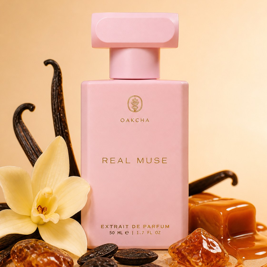 Front view of Real Muse perfume, pink bottle with gold logo, shown with vanilla pods, flower and caramel on beige background